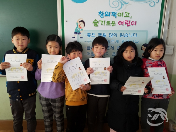 하동군 묵계 초등학교 학생들이 한자 자격검정 합격증을 들고 기념촬영을 하고 있다.