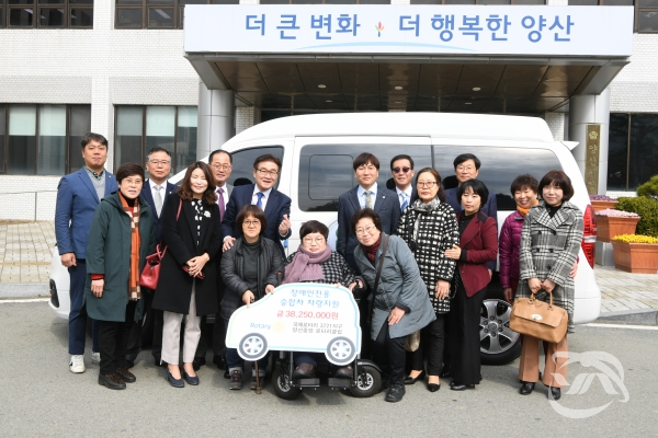 양산시 중앙로터리클럽은 중증 장애인 이동차량을 전달식을 개최하고 기념사진을 찍고 있다.