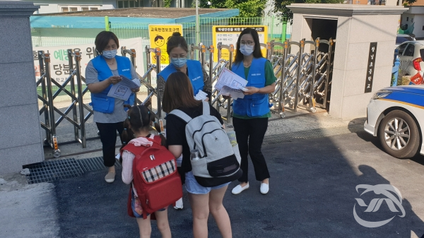 창녕초등학교 앞에서 카페회원과 봉사단원이 아동에게 아동학대 예방 전단지와 홍보물을 나눠주고 잇다.(사진=창녕군청 제공)